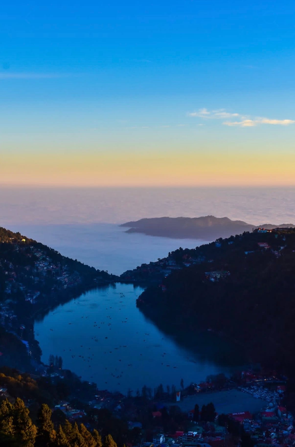 Nainital at dusk from the ridge above the lake — one town in a belt we build right across, from Bhimtal and Bhowali out to Ramgarh, Ranikhet and Mukteshwar.